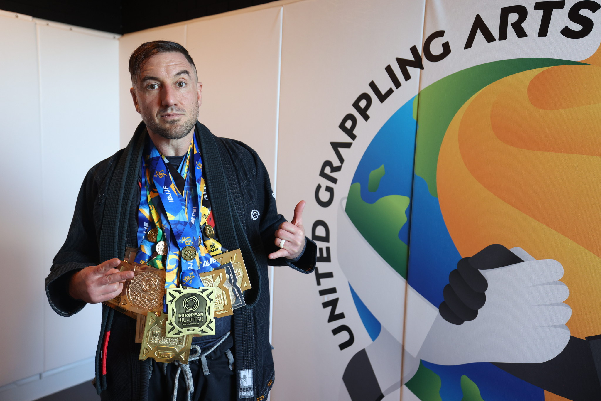 Cj TruHeart standing before the original United Grappling Arts wall mark