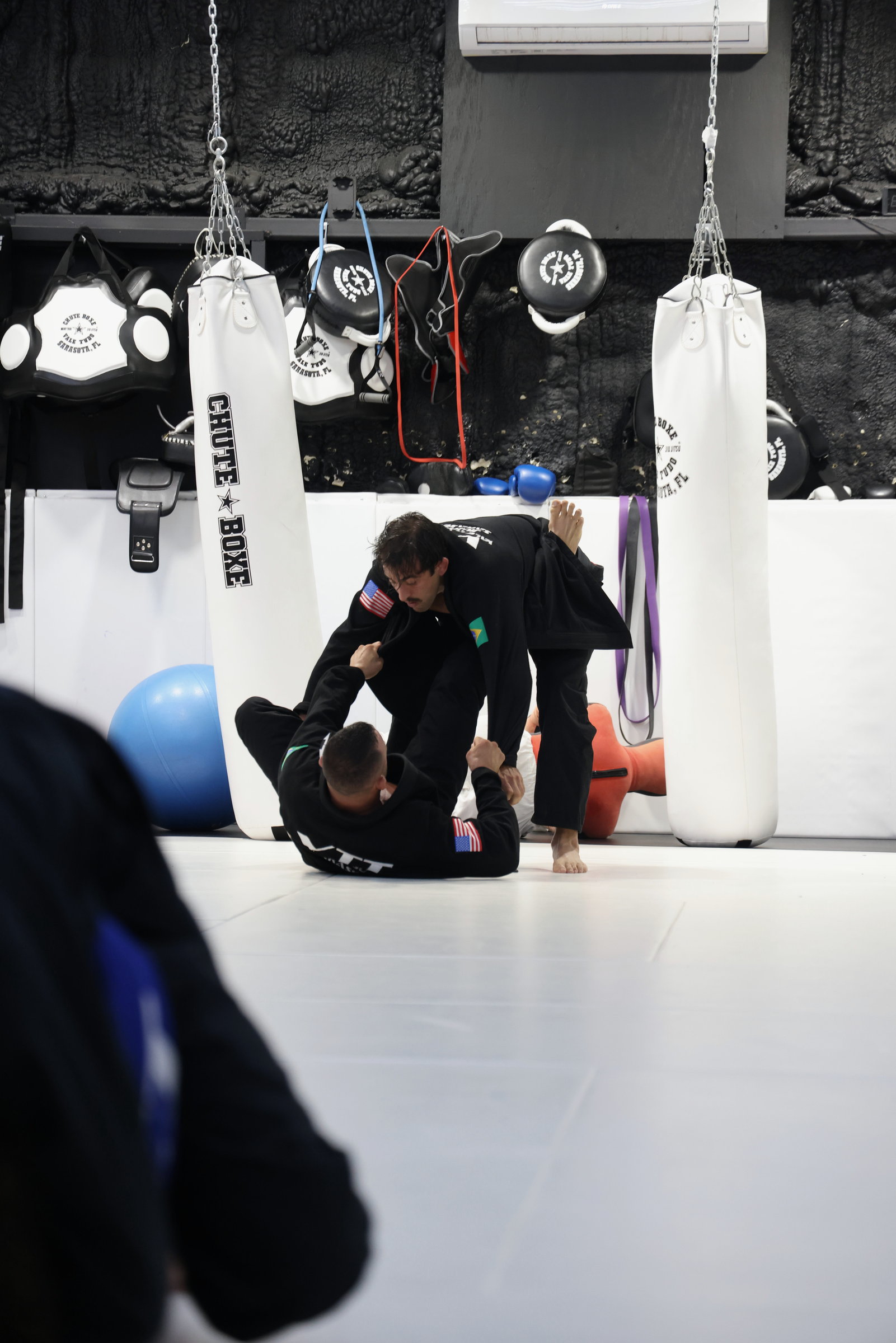 A practitioner seated at the edge of the mat in quiet focus